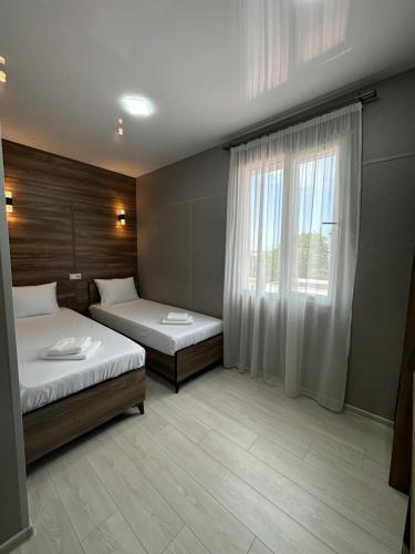 a bedroom with two beds and a window at Avangard in Batumi