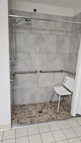 a shower with a chair in a bathroom at SureStay Hotel by Best Western Marienville in Marienville