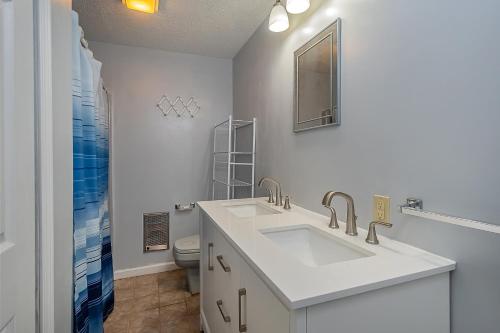 a white bathroom with a sink and a toilet at Lake Life HQ in McHenry