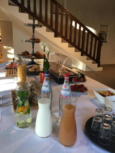 a table topped with bottles and plates of food at Relais Manderen in Manderen