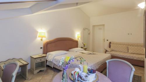 a hotel room with a bed and a table and chairs at Hotel Kursaal in Passignano sul Trasimeno