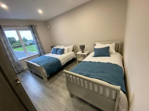 a bedroom with two beds and a window at Ard na Gréine in Stradbally