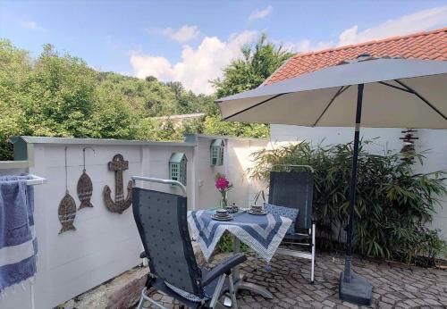 a patio with a table and an umbrella at Apartment Seerose in Remseck am Neckar