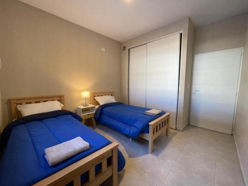 2 camas en una habitación pequeña con 2 camas sidx sidx sidx en Hermoso departamento en Mendoza en Godoy Cruz