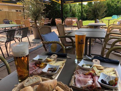 a table with a tray of food and two glasses of beer at Relais Manderen in Manderen