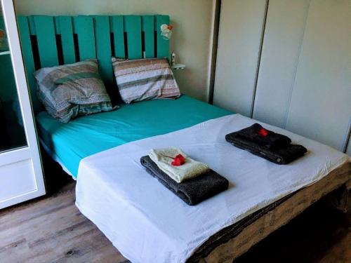 un lit avec deux serviettes dessus dans l'établissement Terrasse vue Mer et port, hyper centre, à Sausset-les-Pins