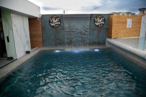 una piscina en una casa con agua. en Vila One Beach Hotel, en Durrës