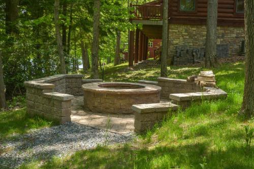 a stone fire pit in the middle of a yard at Lakey McLakeHouse in Swanton