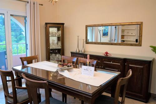 a dining room with a table and a mirror at La Bella Vita - Luxury Holiday House close to Corfu Town in Potamós