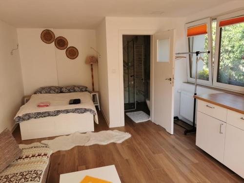 1 dormitorio con 1 cama y ducha a ras de suelo en Maly domek, en Szczecinek
