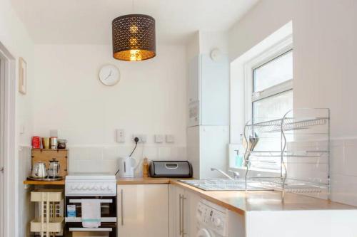 a kitchen with a sink and a stove top oven at Stylish 4BD House with Private Garden - Stratford in London