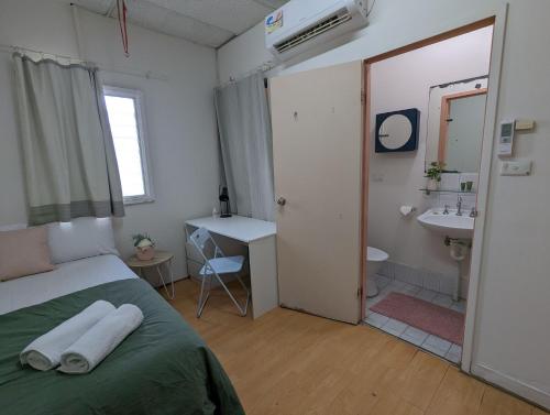 a bedroom with a bed and a bathroom with a sink at Studio 14 Wright Lodge in Adelaide