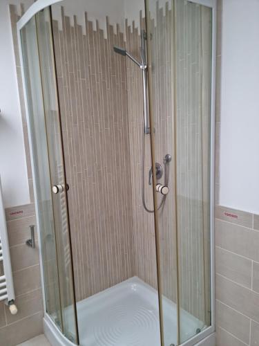 La salle de bains est pourvue d'une douche avec une porte en verre. dans l'établissement Casa vacanza Amanda, à Nicotera Marina