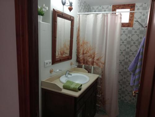 y baño con lavabo, espejo y ducha. en Casa la Pedriza Completa, en Villanueva de Algaidas