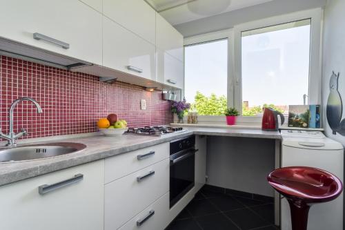 una cocina con armarios blancos y fregadero en Elite Apartments Sopot Center en Sopot