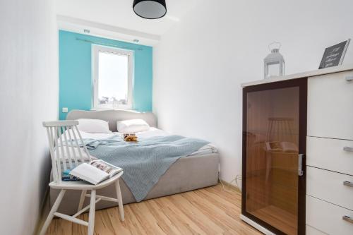 a small bedroom with a bed and a chair at Elite Apartments Sopot Center in Sopot