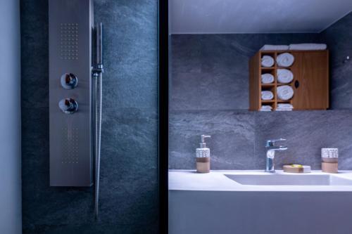 two pictures of a bathroom with a sink and a shower at G.R luxury apartment in Lefkada Town