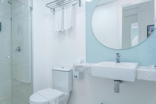 a bathroom with a sink and a toilet and a mirror at Hotel Brisa Praia Pajuçara in Maceió