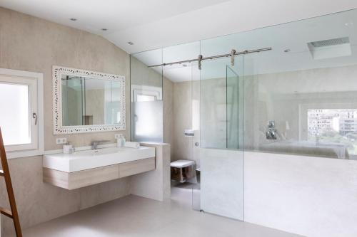 y baño con lavabo, ducha y espejo. en Villa Argiles, en Bunyola