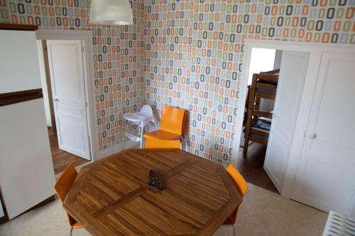 - une salle à manger avec une table en bois et 2 chaises dans l'établissement Le Refuge - Gîte Familial, à Saint-Angel
