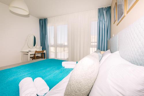 een slaapkamer met een blauw en wit bed en een raam bij Edonia Garden Home Comfortable & stylish duplex apartment with relaxing private garden in Brodarica