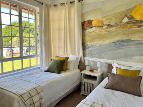 a bedroom with two beds and a painting on the wall at Edgehill in Pietermaritzburg