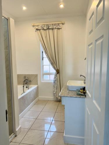 a bathroom with a tub and a sink and a shower at Edgehill in Pietermaritzburg