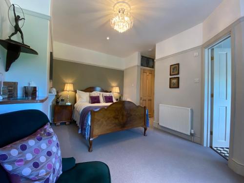 ein Schlafzimmer mit einem großen Bett und einem Sofa in der Unterkunft Downton Lodge Country Bed and Breakfast and; Self Catering in Dartmouth