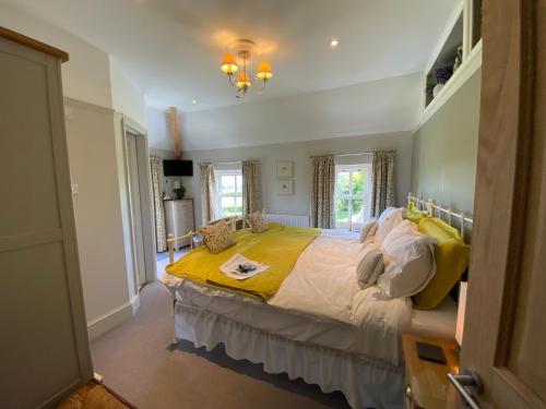 a bedroom with a large bed with a yellow blanket at Downton Lodge Country Bed and Breakfast and; Self Catering in Dartmouth