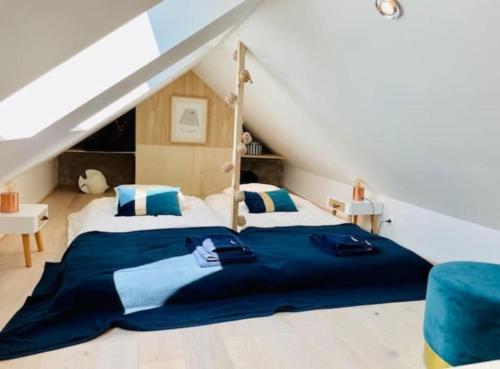une chambre avec un grand lit dans un grenier dans l'établissement Charmant Duplex à 1min La Baule, au Pouliguen