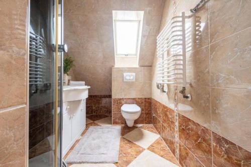 e bagno con servizi igienici, doccia e finestra. di Apartament Centrum Zakopane a Zakopane
