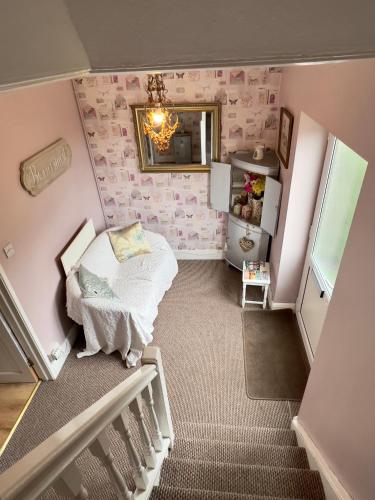 a small bedroom with a bed and a mirror at Prelude Guesthouse, Brigsley Grimsby in Grimsby