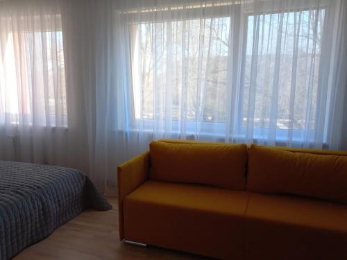 a living room with a couch and a large window at City center apartment in Klaipėda