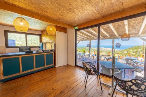 a kitchen and dining room with a view of the ocean at Domaine Bagia Donne in Santa-Reparata-di-Balagna