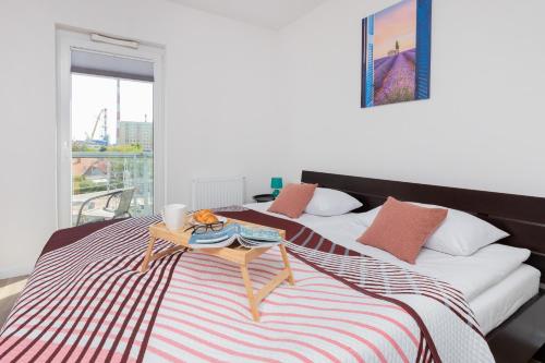 a bed with a tray on top of it at Apartments Gdańsk Kochanowskiego by Renters in Gdańsk
