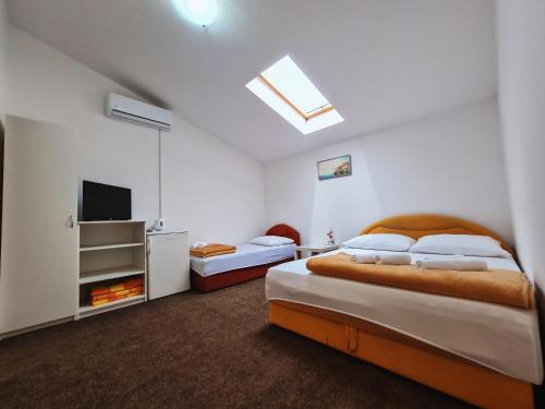 1 Schlafzimmer mit 2 Betten und einem Flachbild-TV in der Unterkunft Guest house Davorka in Neum