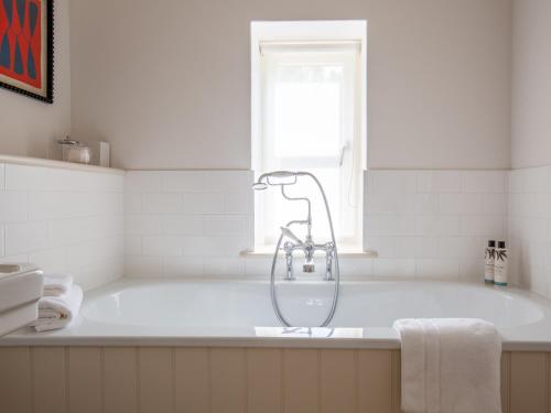 a bath tub with a shower in a bathroom at The Fold in Charlbury