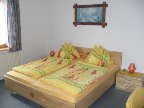 a bedroom with a wooden bed with two pillows at Rainzhof in Aich