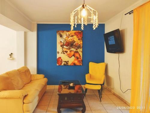 a living room with a couch and a blue wall at Spiro's cottage in Vlachopoulátika
