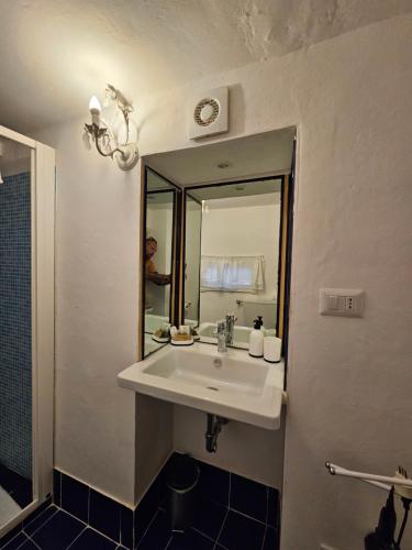 ein Bad mit einem Waschbecken und einem Spiegel in der Unterkunft White Lerici in Lerici