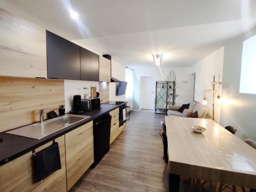 a kitchen with a sink and a table in a room at loft industriel L'Idaho in Sarreguemines