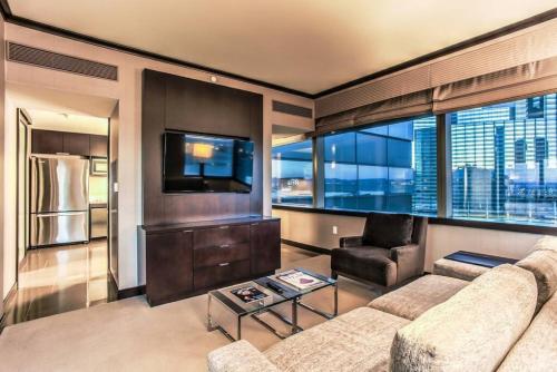 a living room with a couch and a tv at City Center - Panoramic Corner Suite at Vdara in Las Vegas