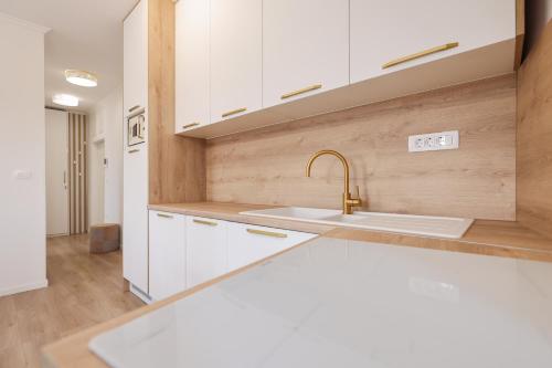 a kitchen with white cabinets and a sink at Sea Gate Apartment in Zadar