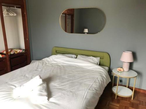 uma cama branca com uma cabeceira verde e um espelho em Casa Ferrel B&B em Ferrel