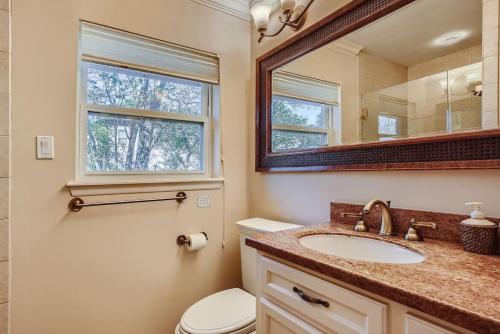 y baño con aseo, lavabo y espejo. en Classic Retreat in Great Neighborhood en Houston