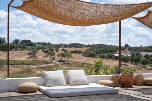 a couch sitting on a patio with a view of a field at Cucumbi in Santa Susana