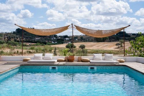 una piscina con sillas y una hamaca junto a en Cucumbi, en Santa Susana