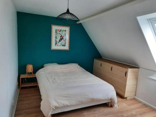 une chambre avec un lit et un mur bleu dans l'établissement Charmante maison 8 personnes à 2 pas de Wimereux, à Wimille