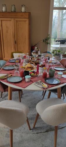 a long table with plates and dishes on it at Chambres d'hôtes le Domaine de Lugazaut in Vielle-Soubiran