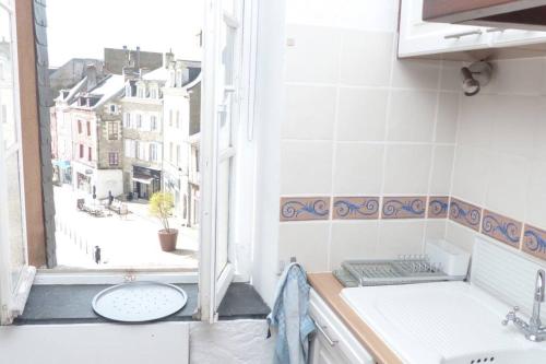 eine Küche mit einem Waschbecken und einem offenen Fenster in der Unterkunft Exceptionnel Appartement à Vannes, vue sur les remparts in Vannes